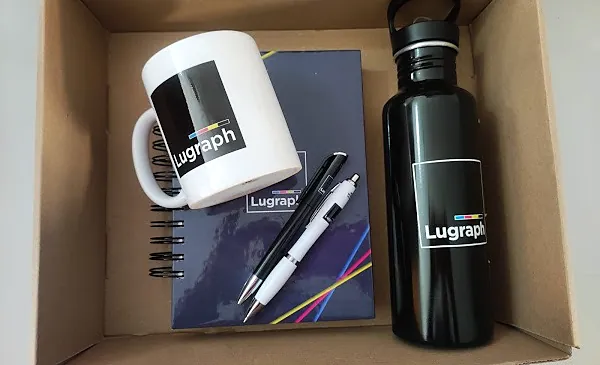 Caja con un tazón, una botella negra, una libreta y dos lápices con el logo de Lugraph