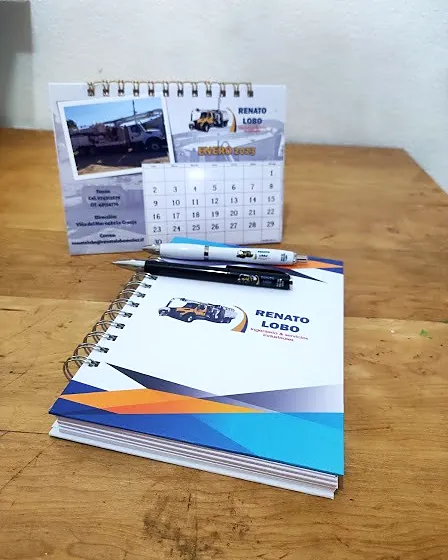 Agenda anillada, calendario de escritorio y dos lápices con el logo de Renato Lobo