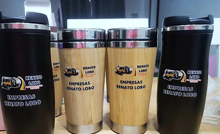 Cuatro vasos térmicos, dos negros y dos de bambú, con el logo de Empresas Renato Lobo