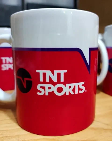 Tazón blanco con franja roja y logo de TNT Sports, con otros iguales detrás
